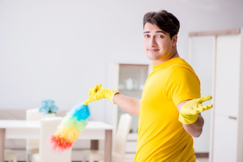 Homme nettoyant avec un plumeau