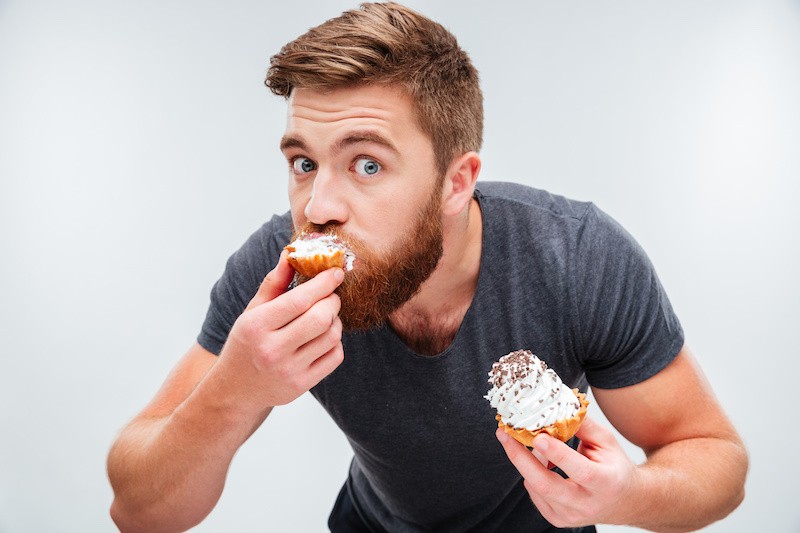 man eating cupcakes in a sexy way