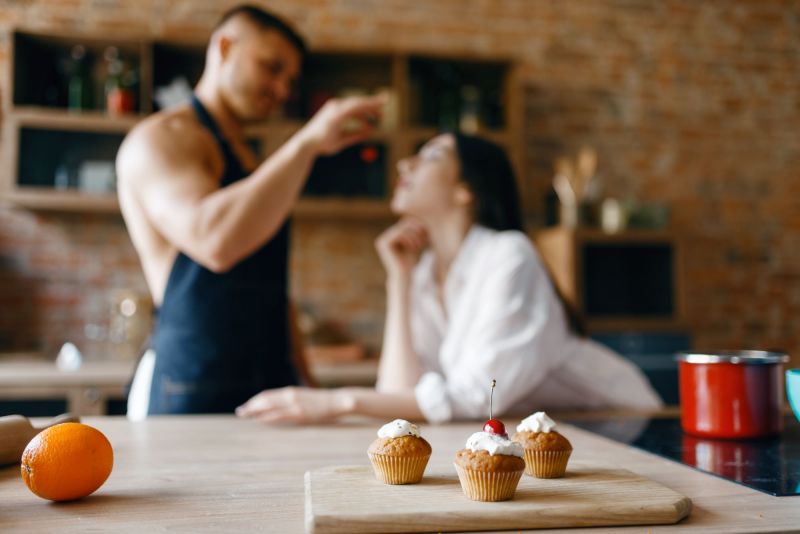 Man feeding woman in kitchen