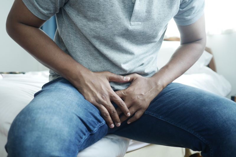 Man holding crotch in painful pose