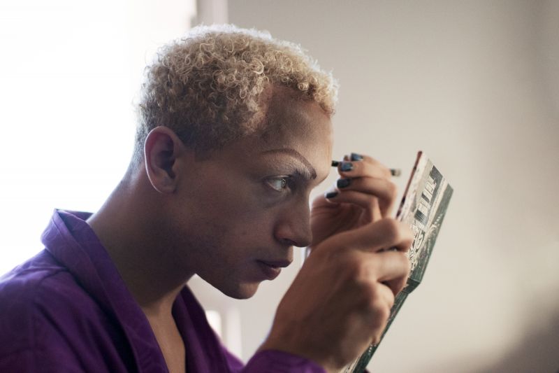 Man in drag putting on make up