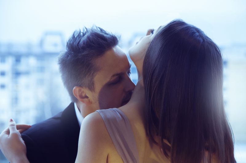Man kisses woman's neck passionately