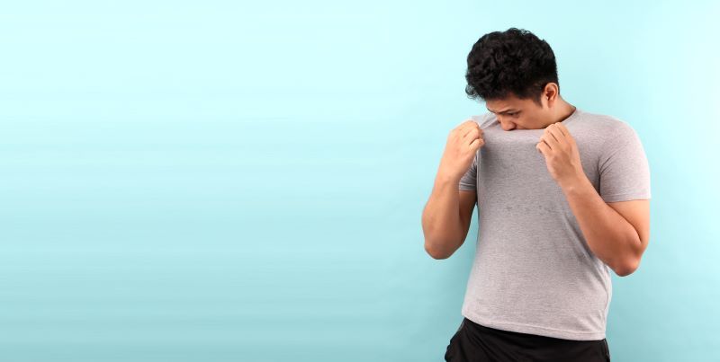 Man sniffing his t-shirt