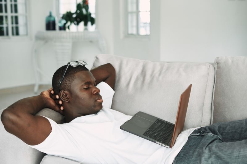 Homme regardant un film à la maison sur son ordinateur portable