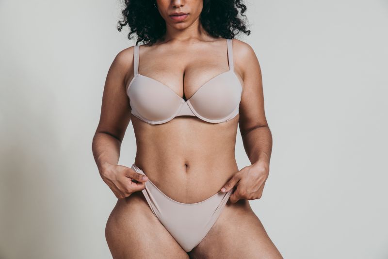 Midsection woman posing in beige lingerie