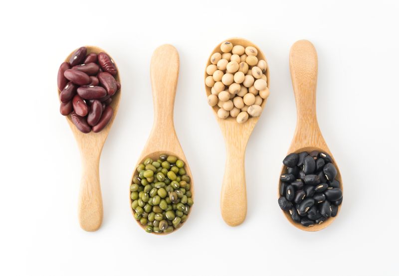 Mixed beans in wooden spoons