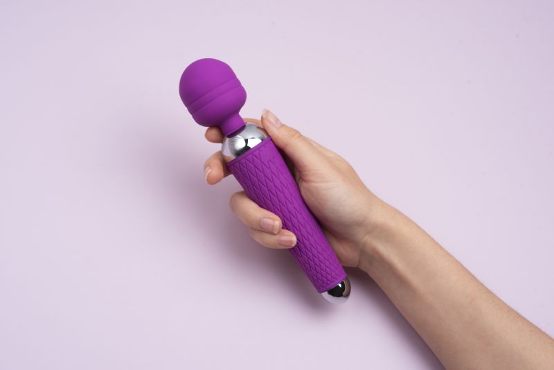 Person holding wand sex toy