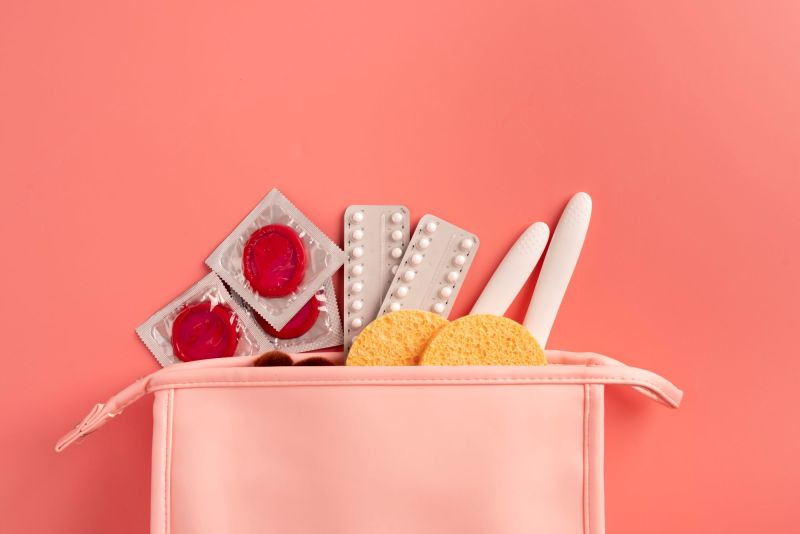 Pink bag with contraception and sexual health items
