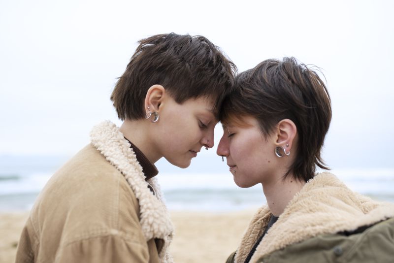 Queer couple standing close outside