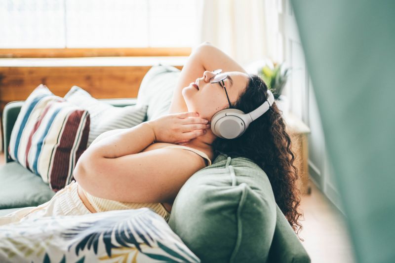 Femme détendue écoutant de la musique sur un canapé