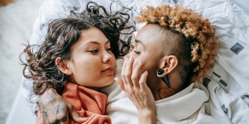 Romantic couple in bed touching each other's faces