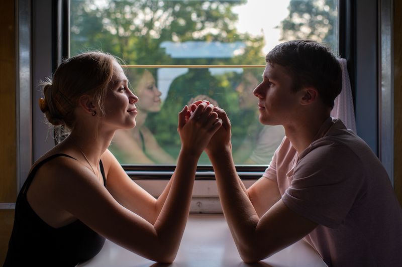 Couple romantique main dans la main dans un train