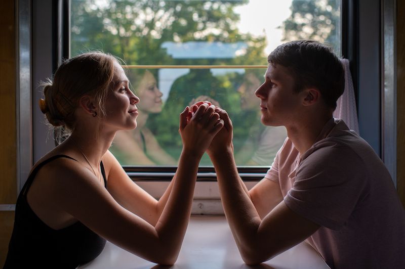 Romantic couple holding hands on a train