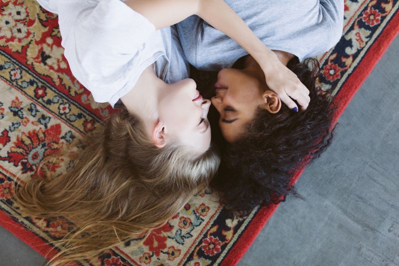 Couple de lesbiennes romantique embrassant sur un tapis