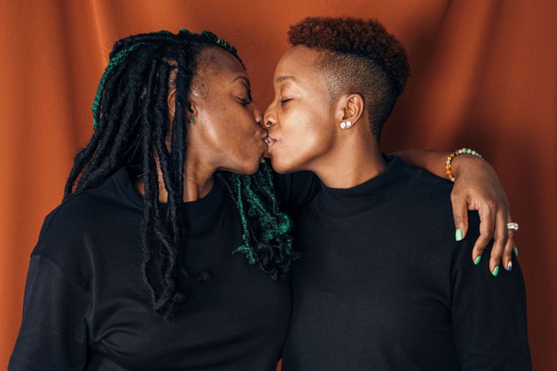 Sensual couple kissing orange background