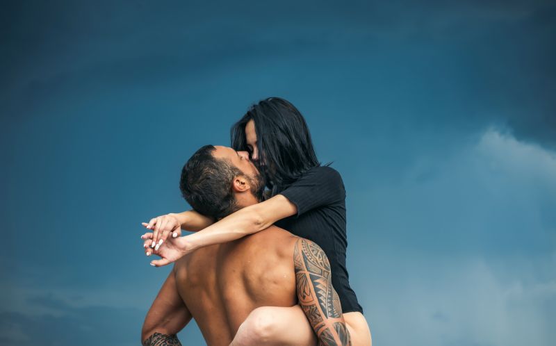 Sensual couple on beach with blue sky