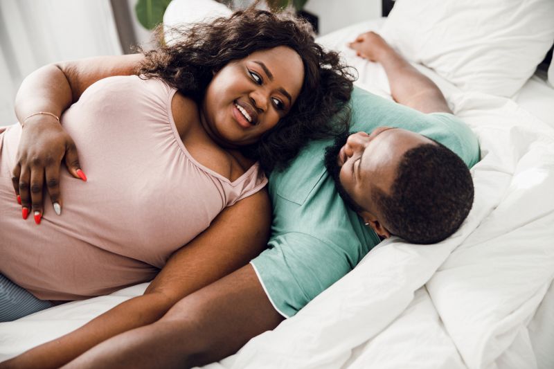 Smiling couple cuddling in bed