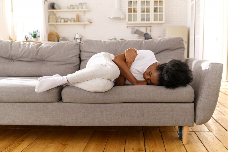 Stressed sad woman lying on couch