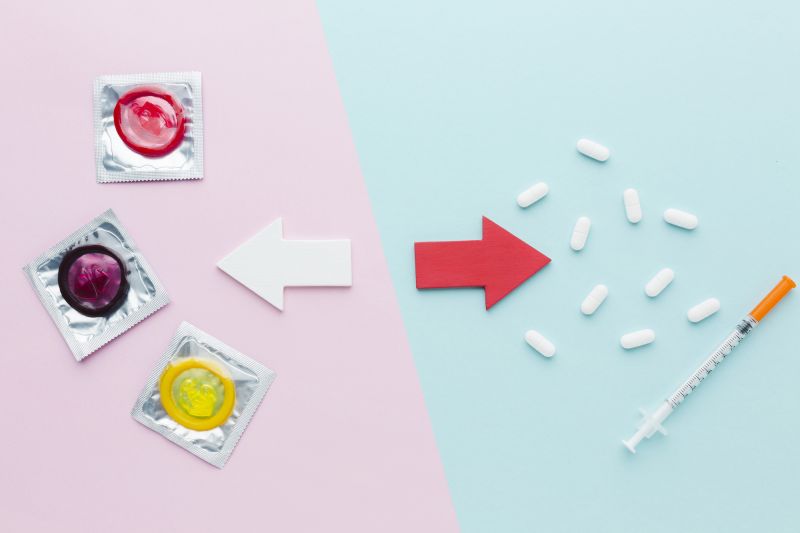Top view composition of contraceptives on pink and blue background