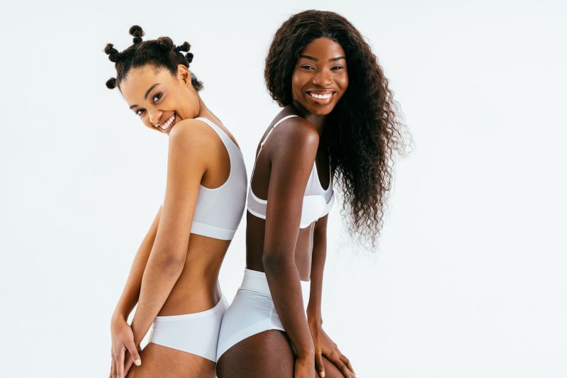 Two smiling women in white lingerie