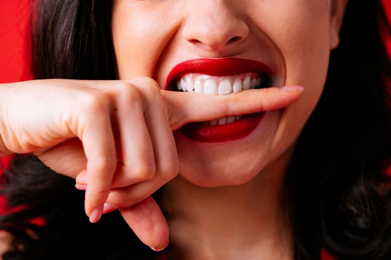 Woman biting down on her own finger