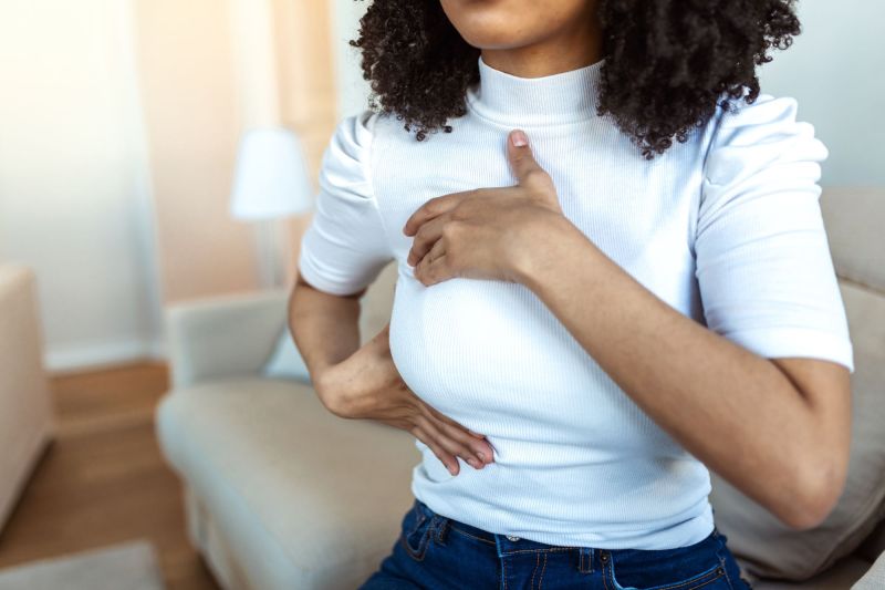 Woman checking breasts at home