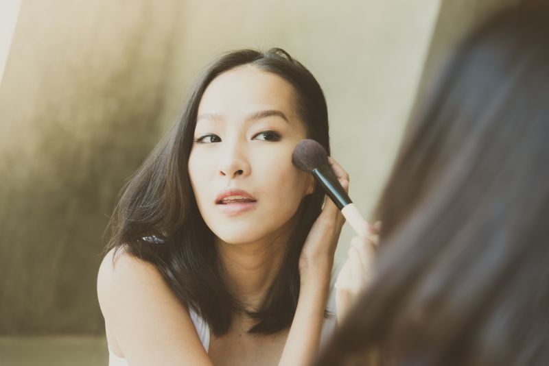 Woman doing make up in mirror