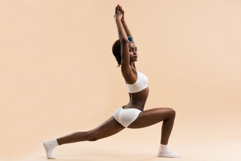 Femme faisant la pose de guerrier de yoga