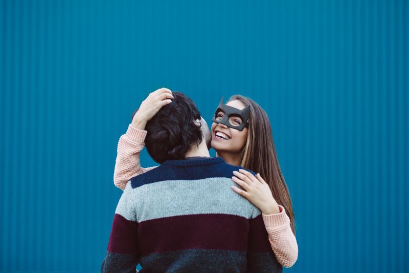 Woman in mask hugging man