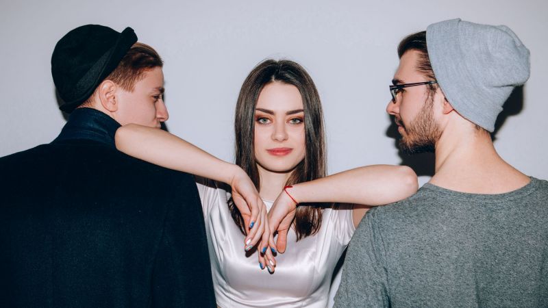 Woman leaning elbows on two men