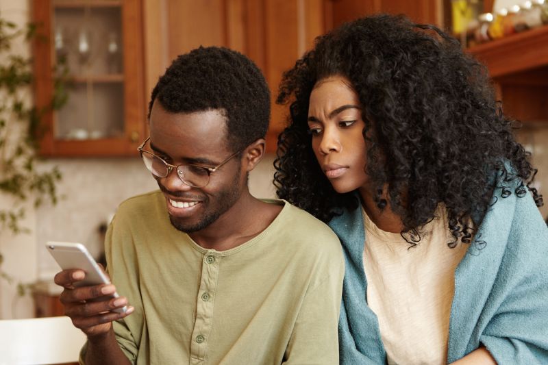 Woman looks at boyfriend on phone angrily