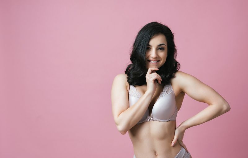 Woman posing in lingerie on pink background