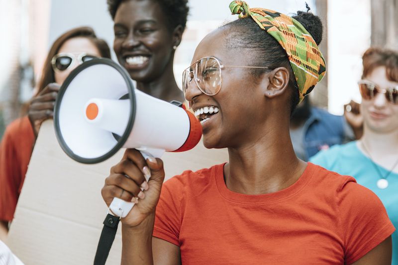 Heureux les jeunes femmes avec un orateur lors d'une manifestation