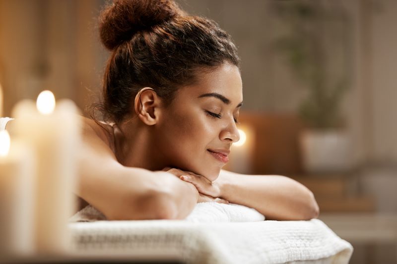 Woman relaxing in spa with candles