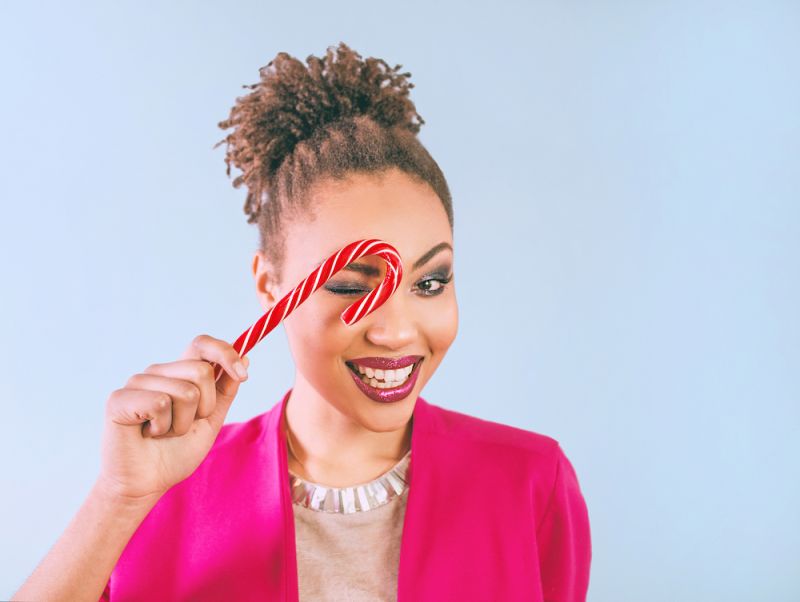 Woman smiling holding candy cane