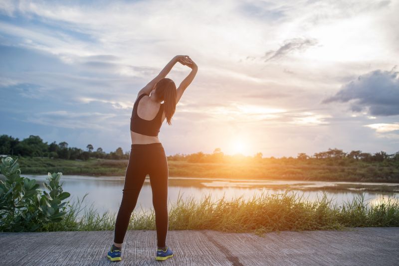 Woman stretching outside in workout gear