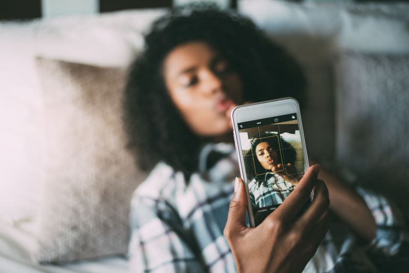 Femme soufflant un baiser à la caméra au lit