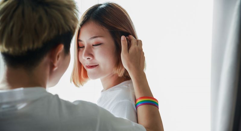 Woman touches hair of her girlfriend