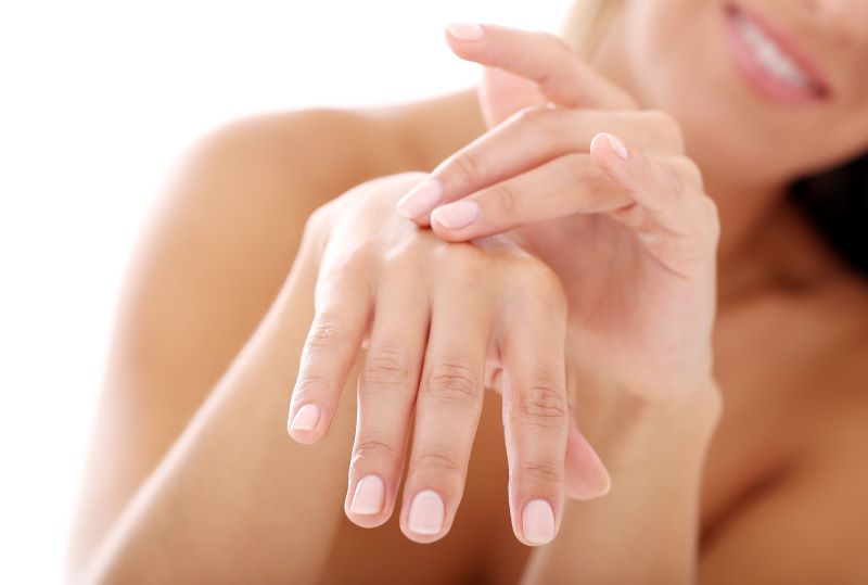 Femme touchant ses mains et ses ongles