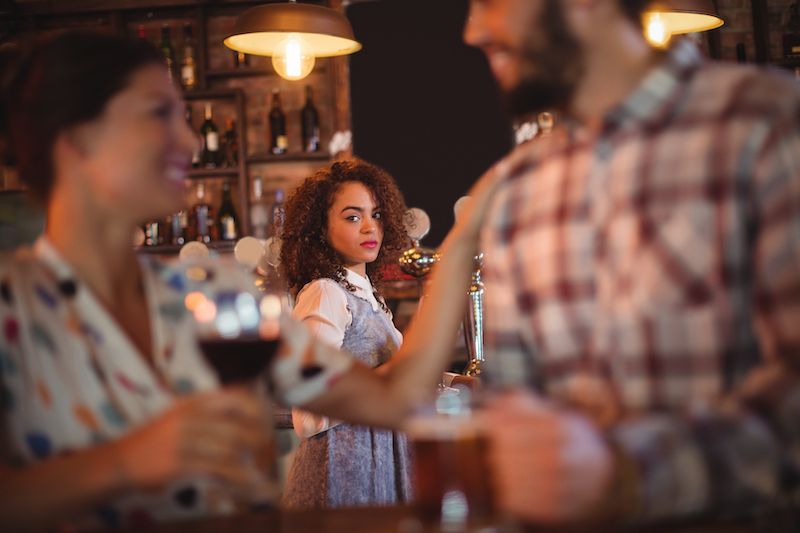 Woman looking jealous watching a couple across the room