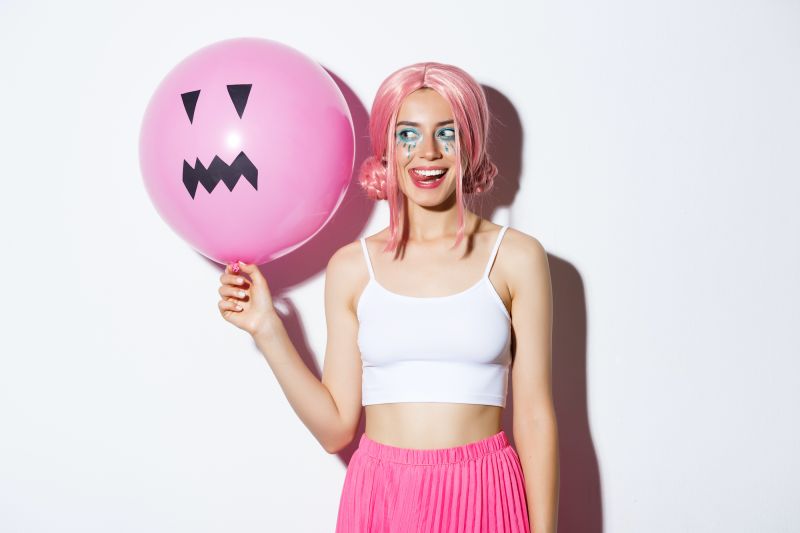 Woman with pink balloon in pink wig halloween costume