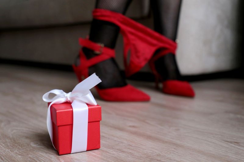 Christmas gift next to woman's ankles with panties