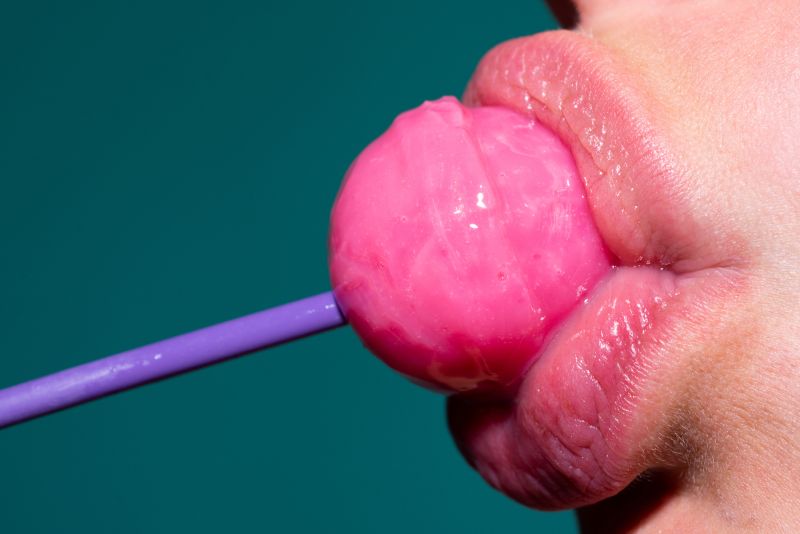 Woman's mouth close up with lollipop