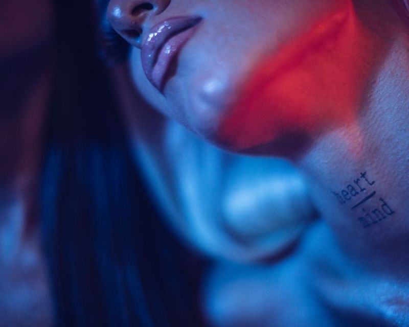 woman's neck with heart and mind text