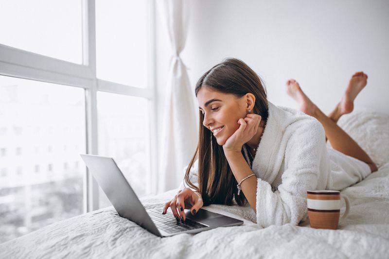 Woman in bed chatting online