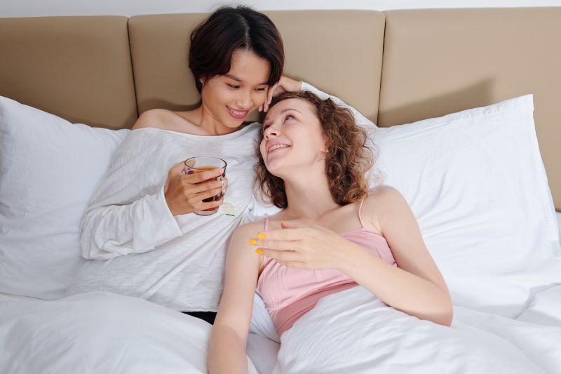 Jeune couple souriant au lit le matin