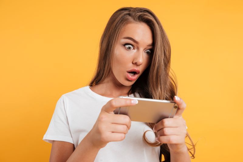 Young woman looking shocked at her phone
