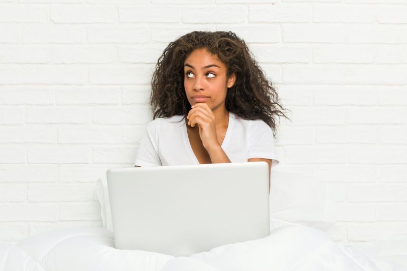 Woman looking thoughtful in bed