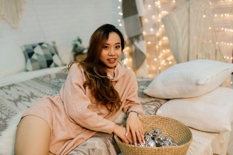 Woman smiling on bed with baubles