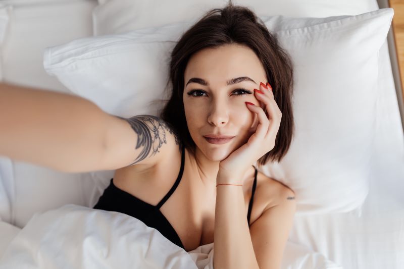 Woman taking selfie in bed